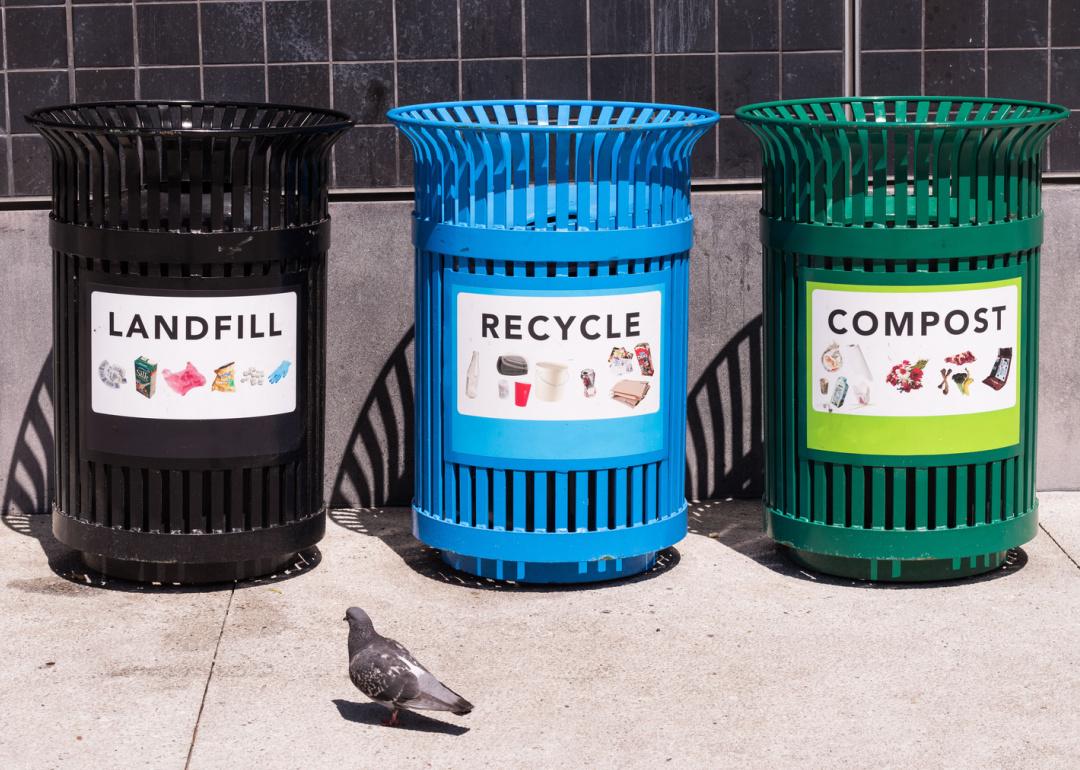 Landfill, recycle and compost bins on a city sidewalk.