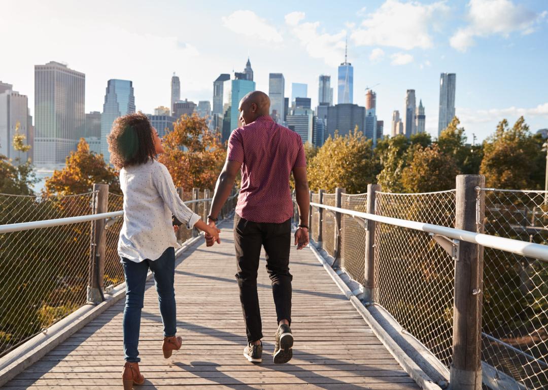 Couple walking on elevated park in New York with skyline