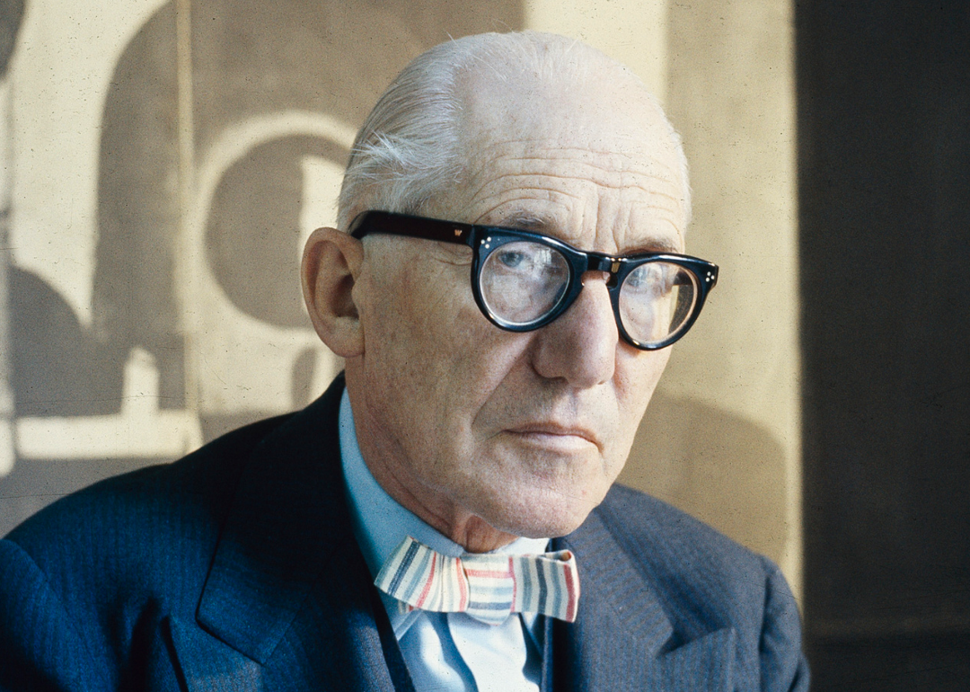 Le Corbusier poses in his studio.