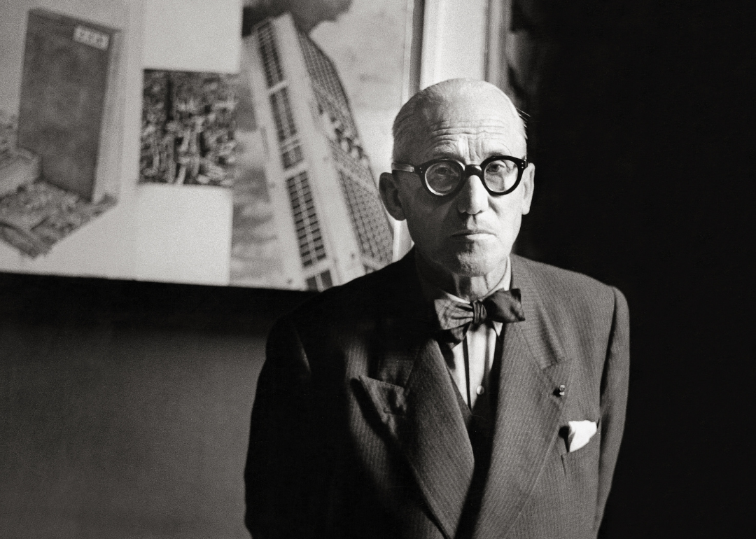 Portrait of Le Corbusier standing in his studio.