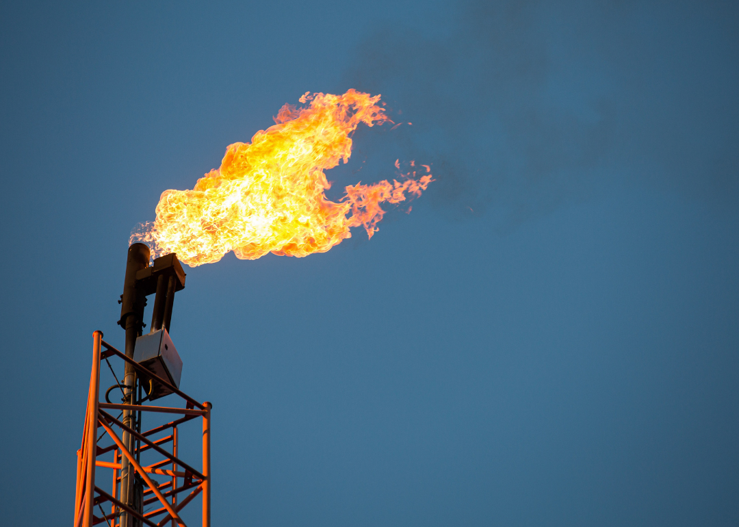 Burning flare at an oil extraction area against sky