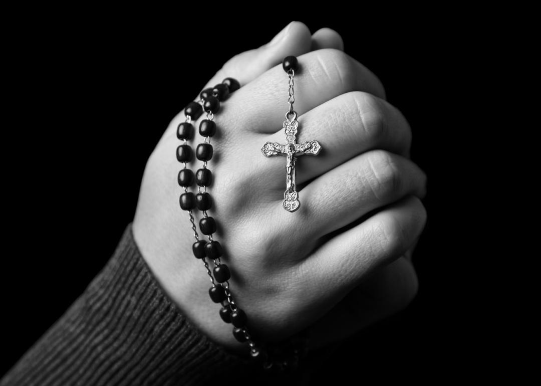 Hands holding a Catholic rosary.