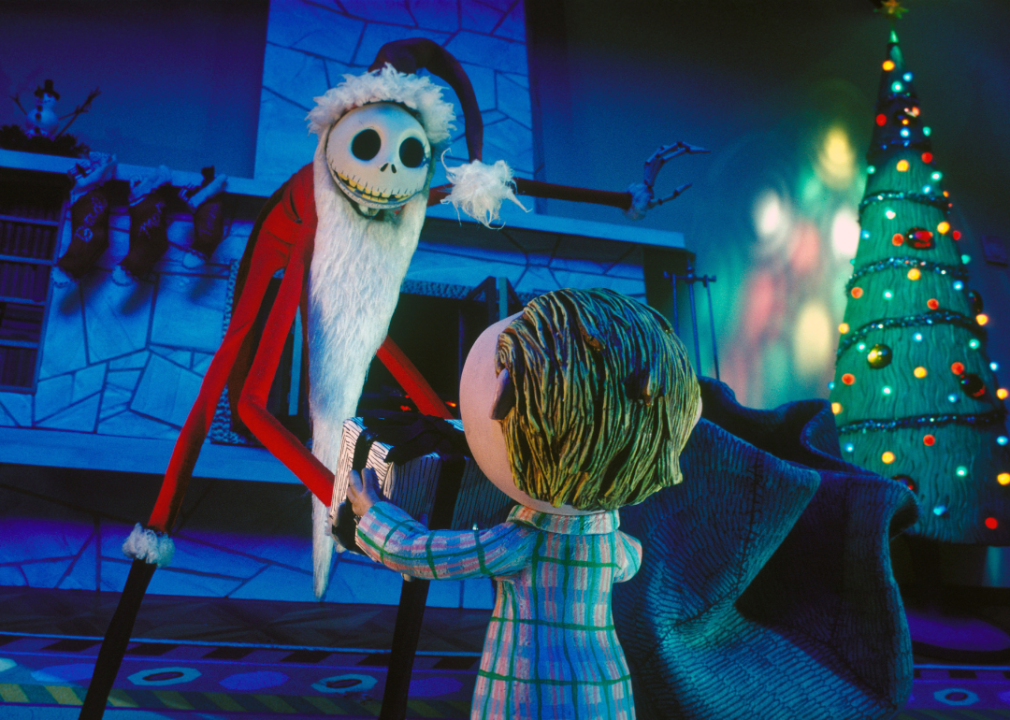 Still frame from ‘A Nightmare Before Christmas’ with Jack Skellington dressed as Sandy Claws handing a gift to a child.