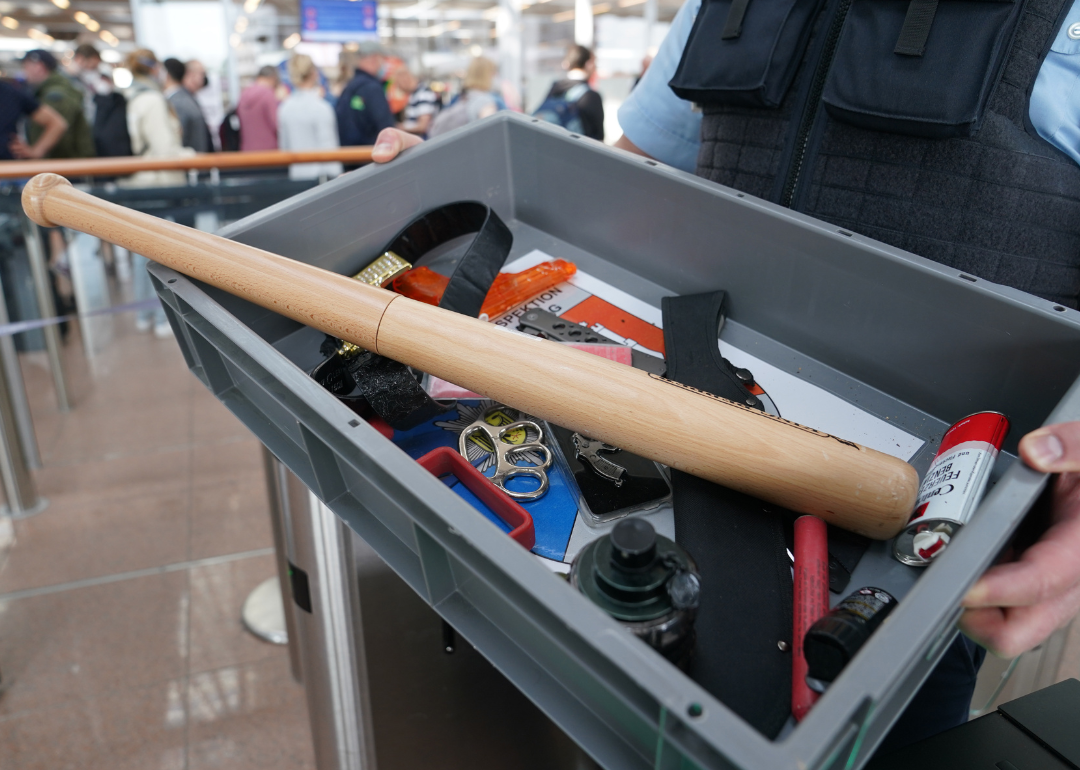 A person holds up a box of confiscated items outside the airport security checkpoint.