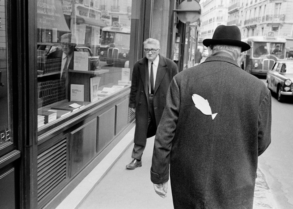 Man walking with a paper fish on his back.