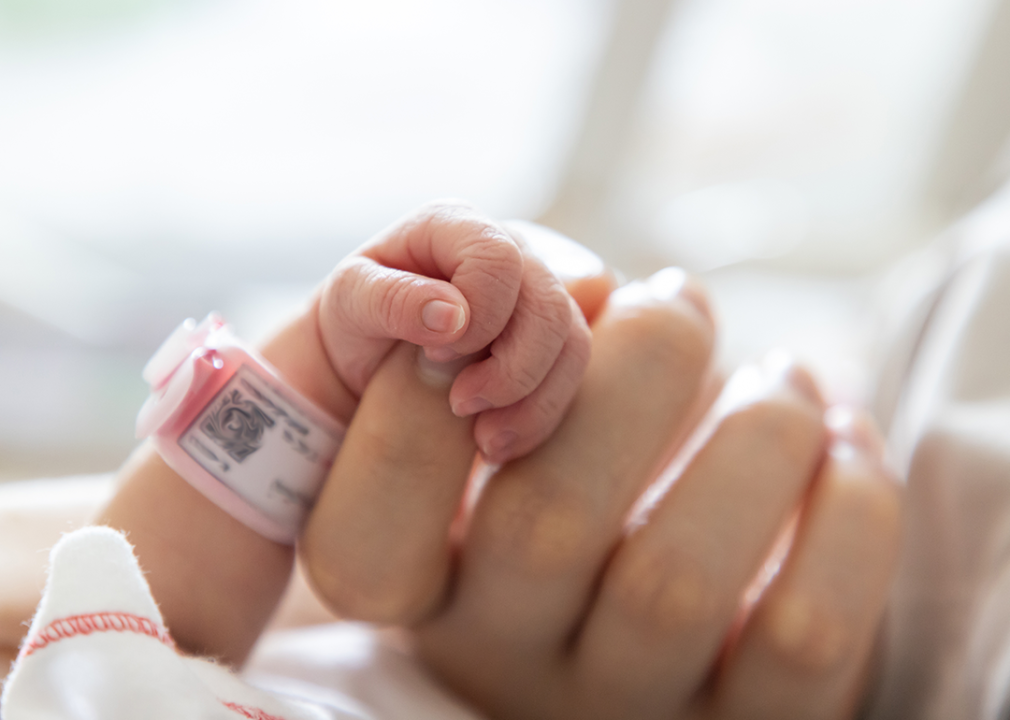 Close up preterm baby hand holding an adult