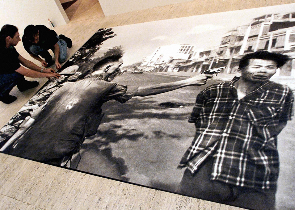 A large print of Eddie Adams ‘Vietnam Execution’ is prepared for installation in a gallery.