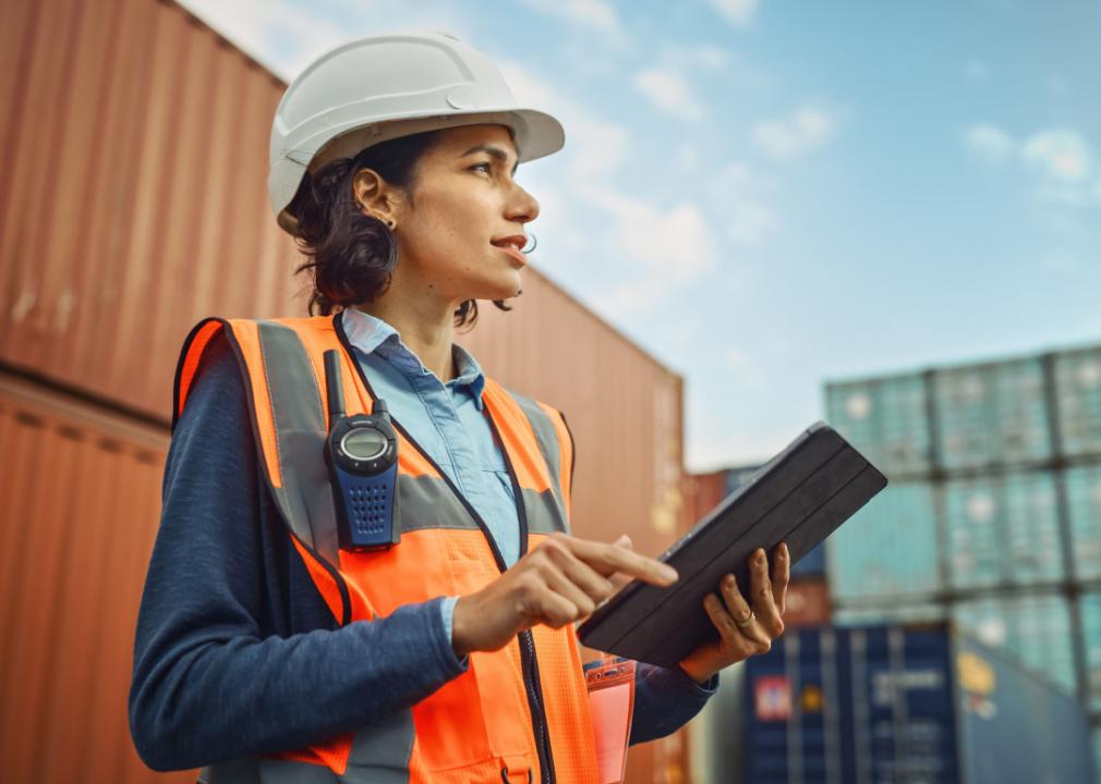Supervisor in shipping container terminal holding tablet.