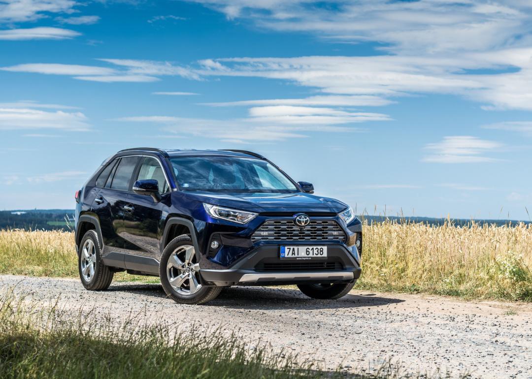 Dark Blue Toyota RAV4 parked beside field