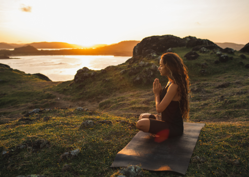 Woman practicing yoga at sunrise