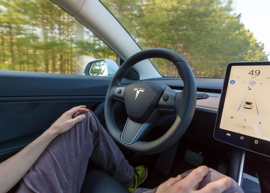 Person driving a Tesla in autopilot mode