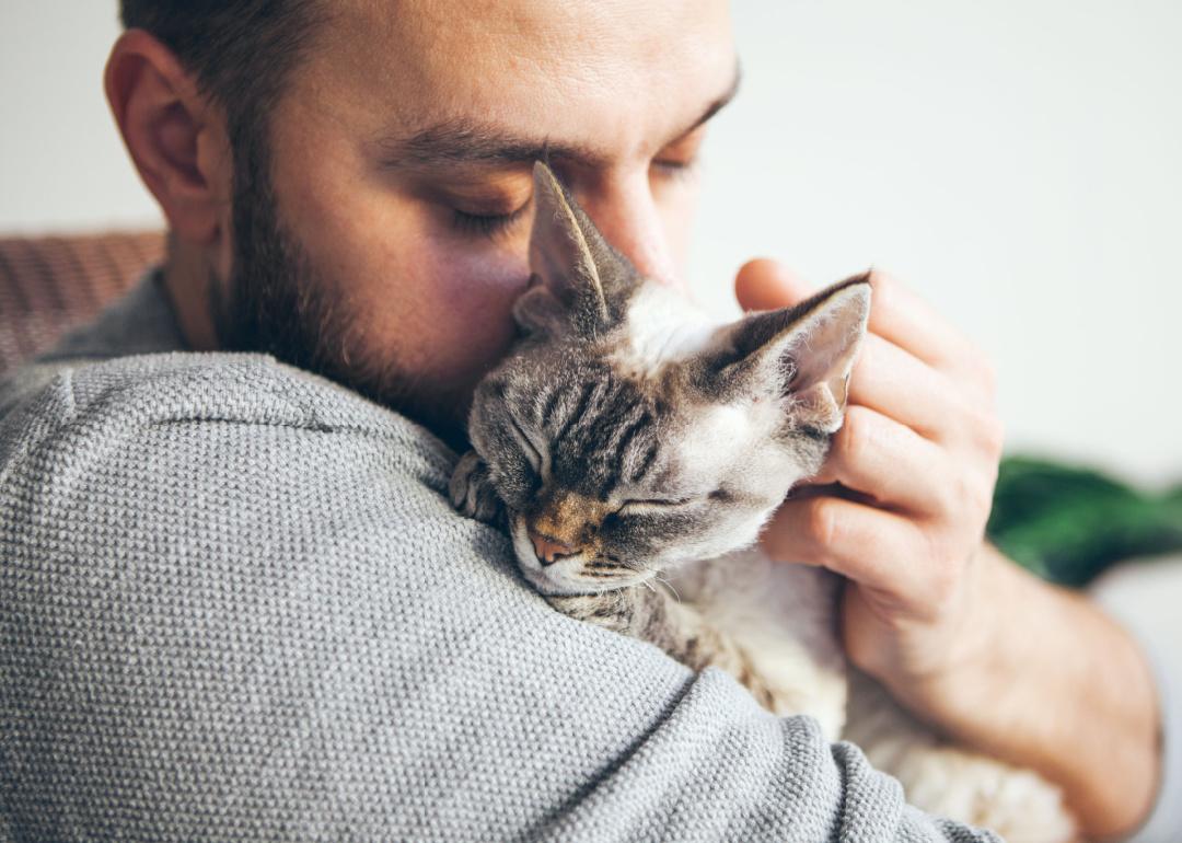 Man cuddling with cat.