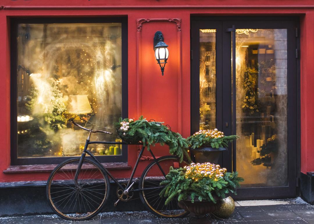Red storefront with bicycle decorated for holidays