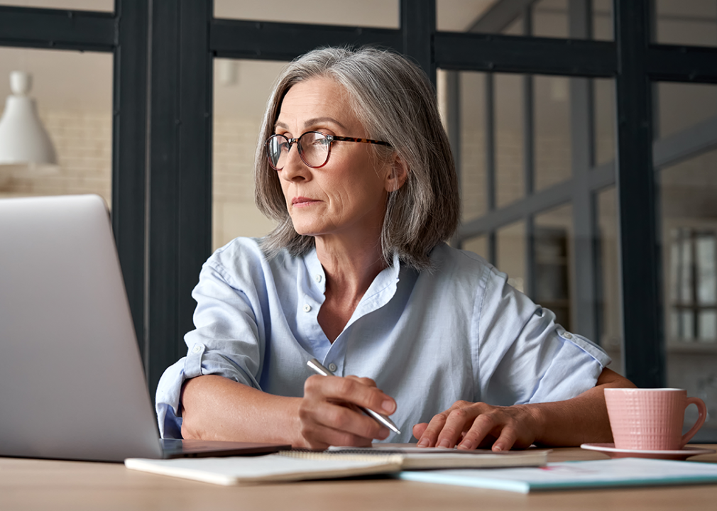 Serious mature woman looking at laptop.