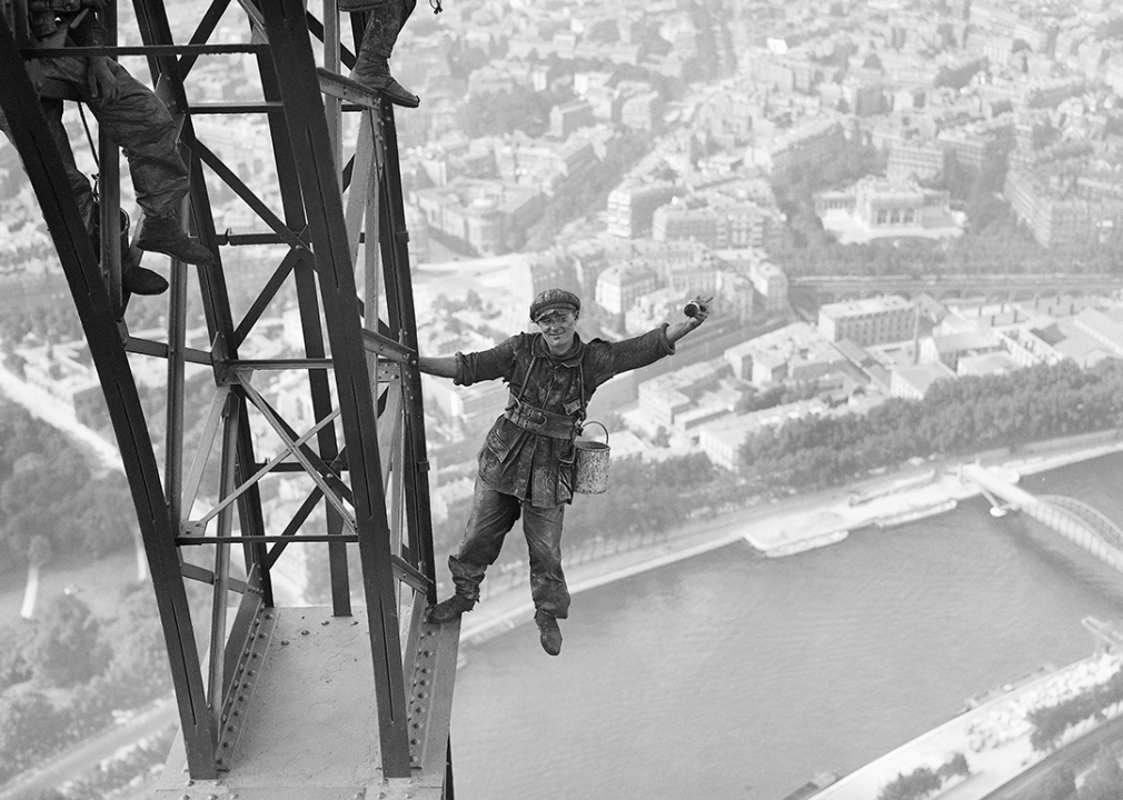 Eiffel Tower painter waves for a photograph.