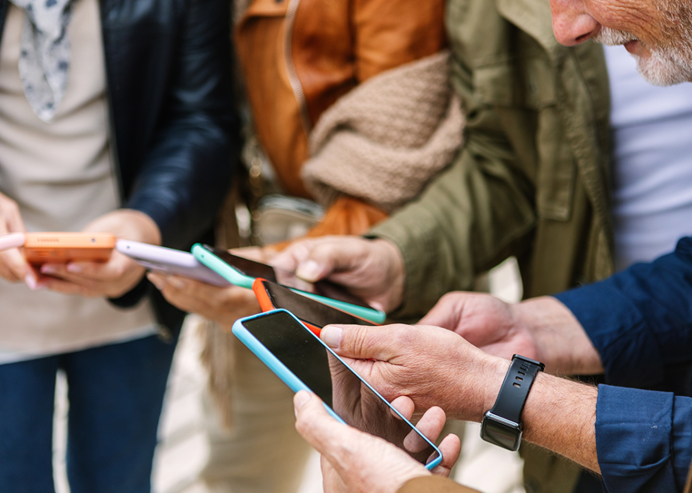 Close up view of senior group of people using smartphone.
