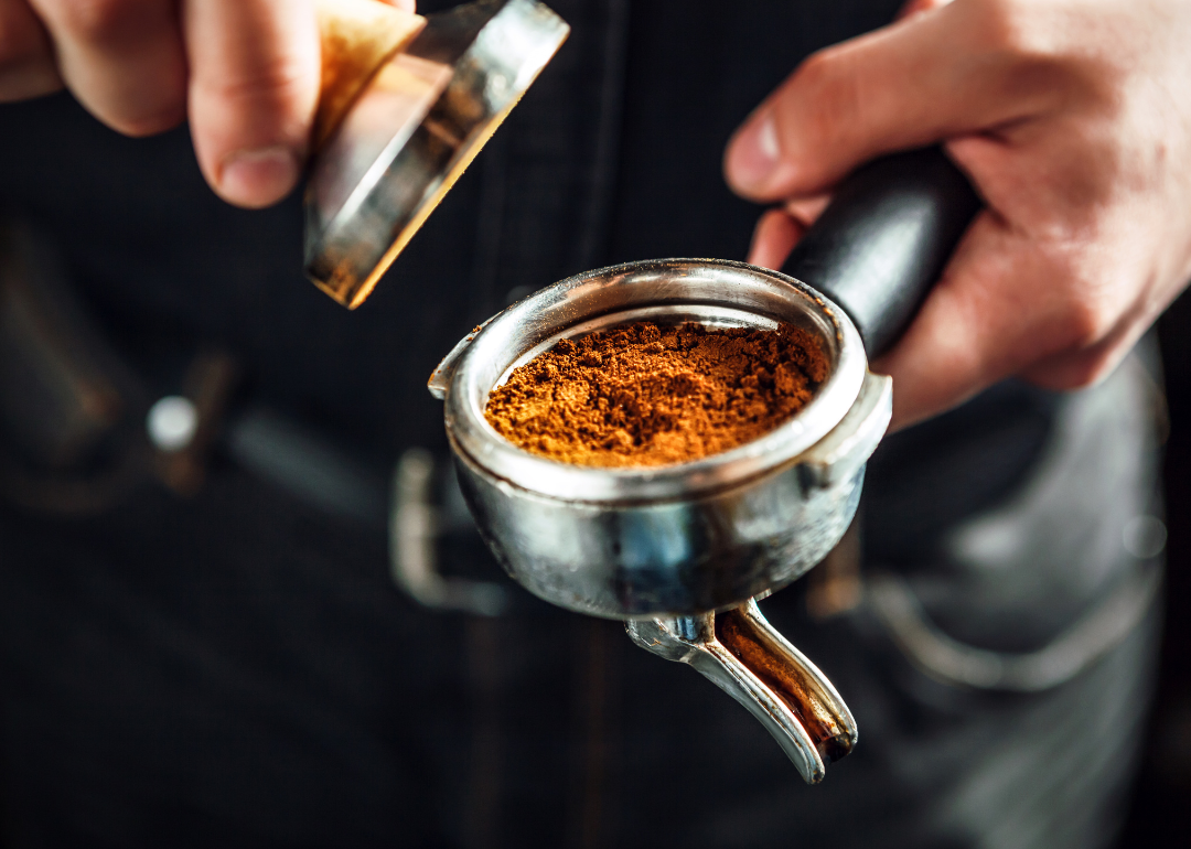 Barista tamping espresso grounds.