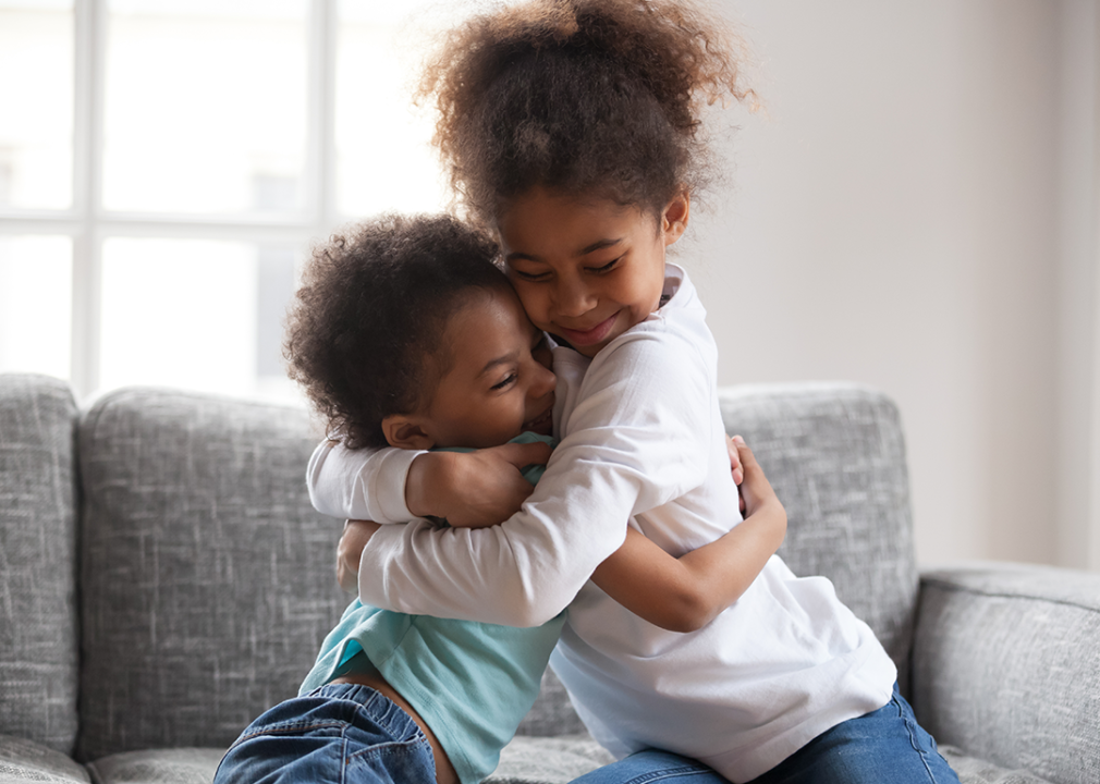 Two siblings hug each other.