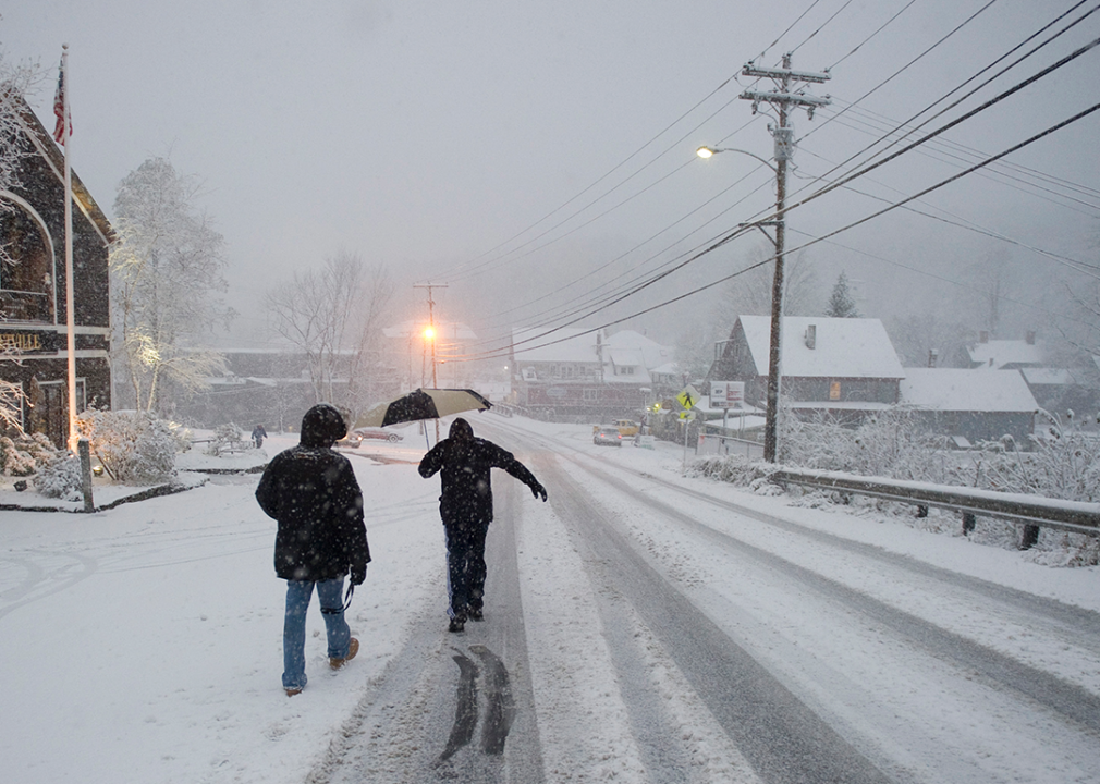 Two men walk down a road in southern Vermont during October snowstorm.
