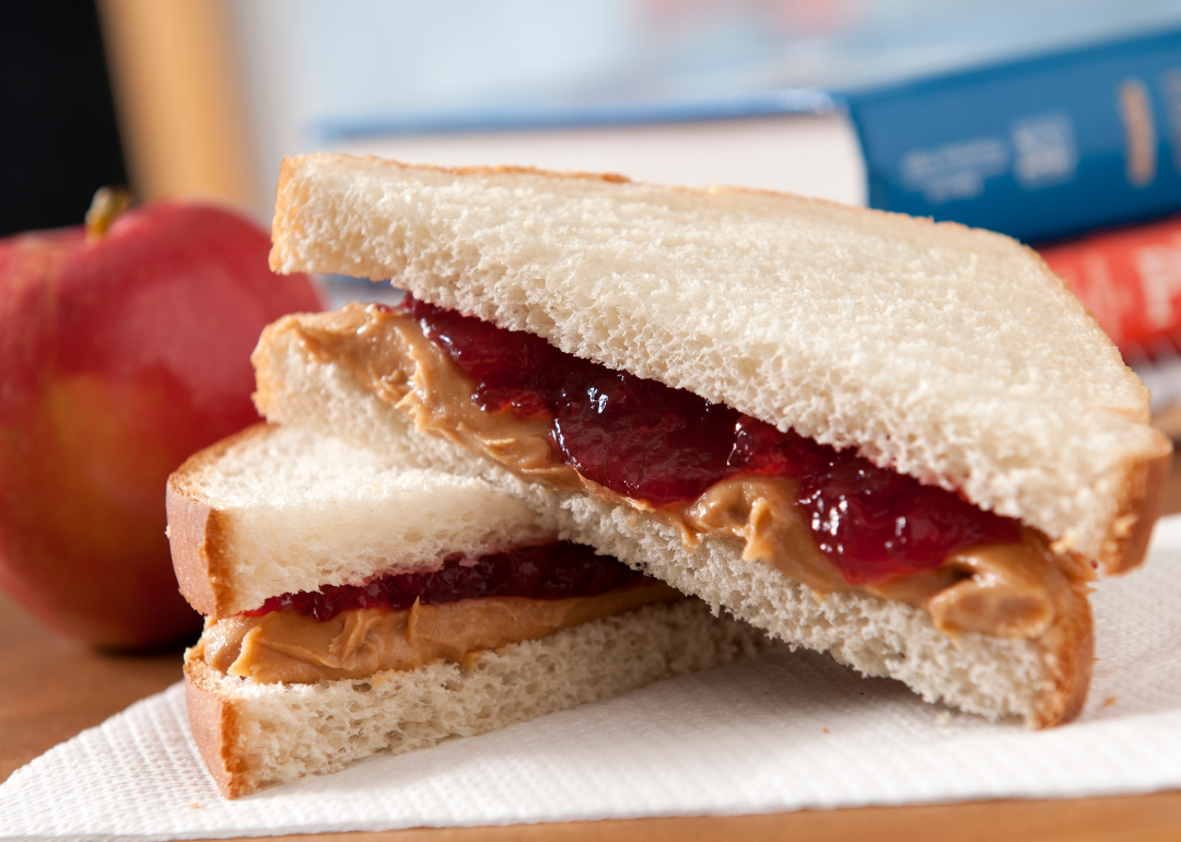 Peanut butter and jelly sandwich on white bread, sliced diagonally.