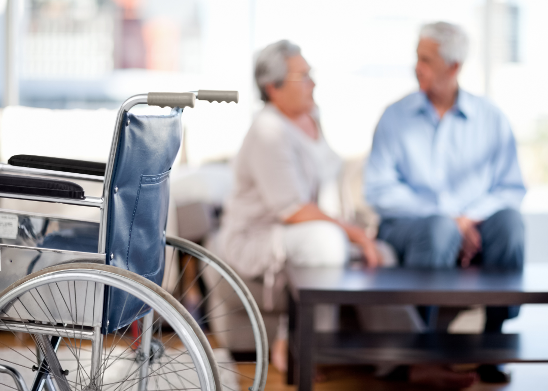 Wheelchair with couple talking in background.