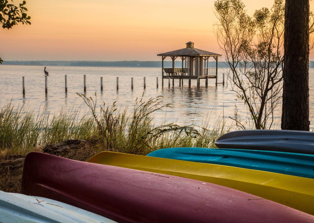 Gazebo and canoes on the shore of Mobile Bay at sunset.