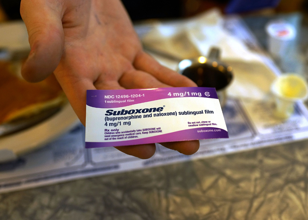 Hand holding a small box of Suboxone.