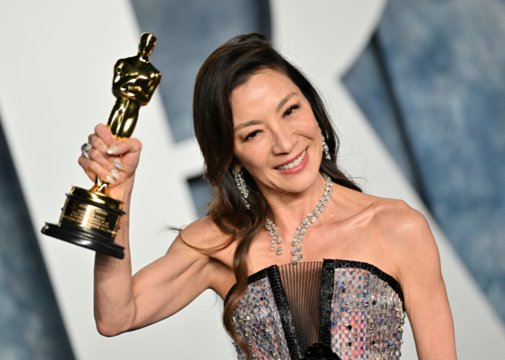 Michelle Yeoh poses with Academy Award at Vanity Fair Oscar Party.