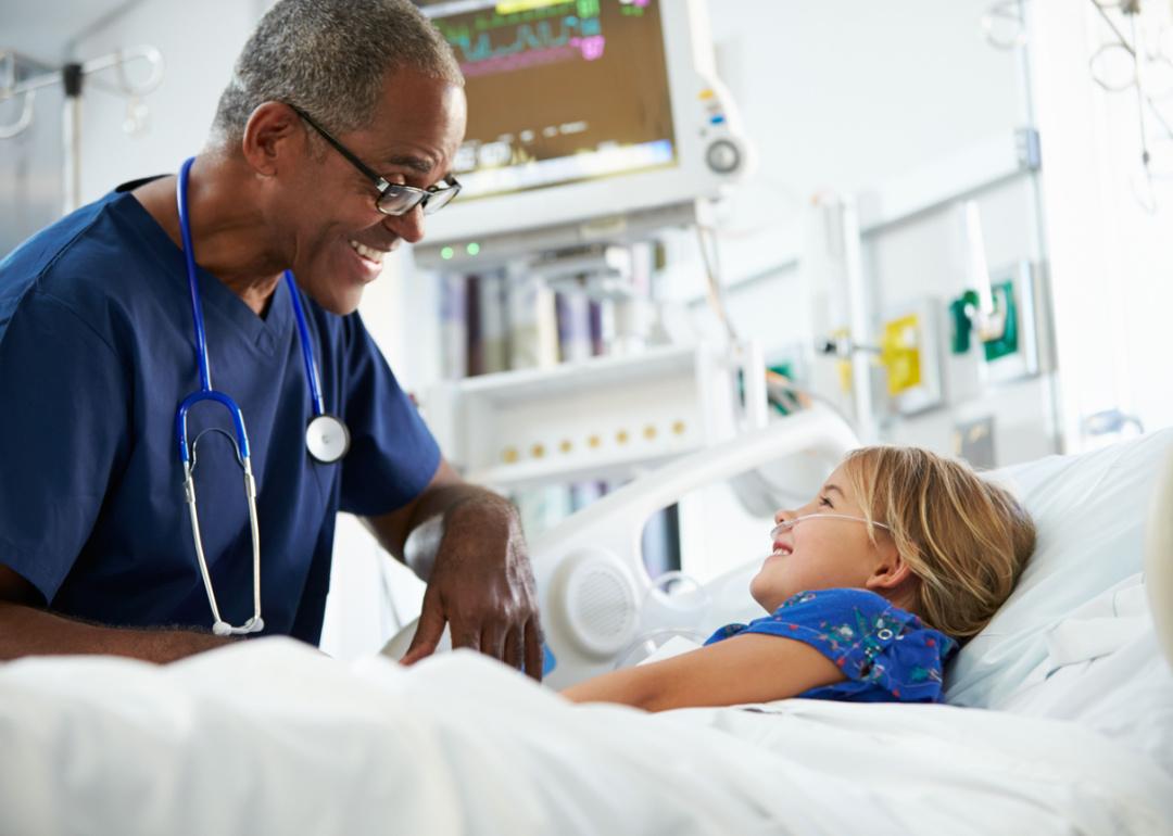 Young child talking to nurse in pediatric care unit.