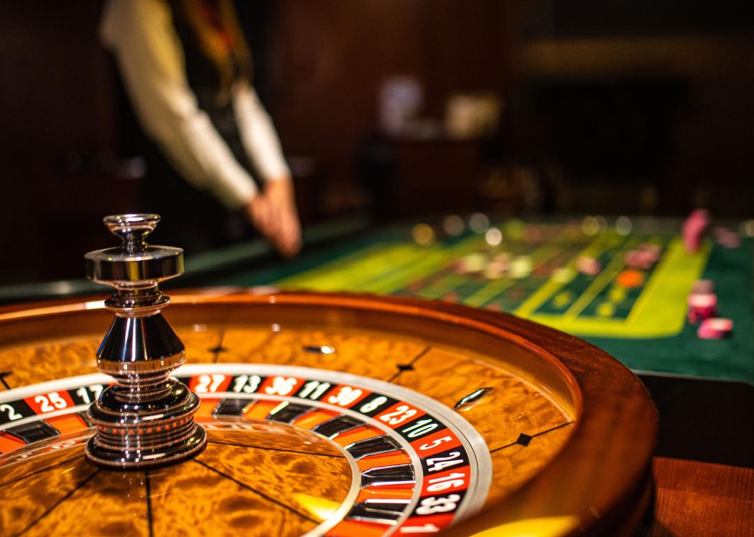Roulette wheel with poker table in the background
