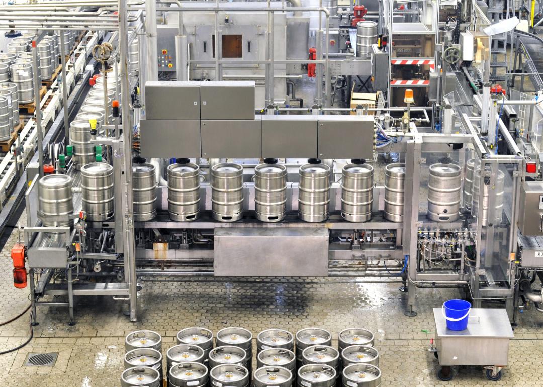 Overhead view of kegs being prepared in a brewery.