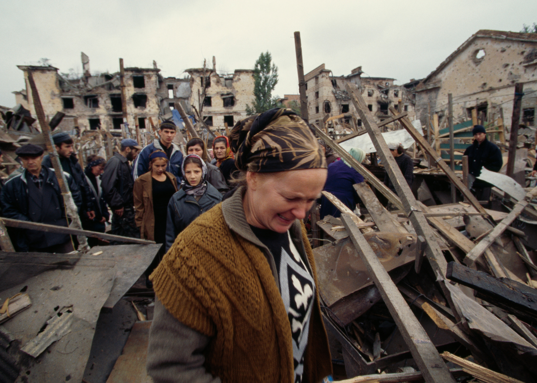Emotional civilians return to survey damage in Grozny market after bombing.