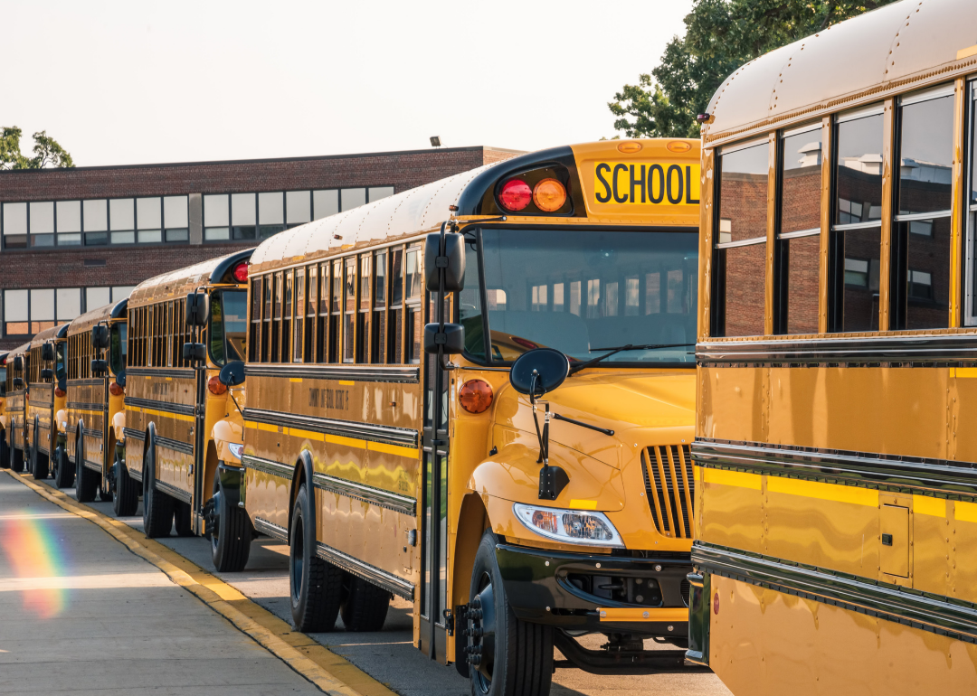 Yellow buses lined up in front of school.