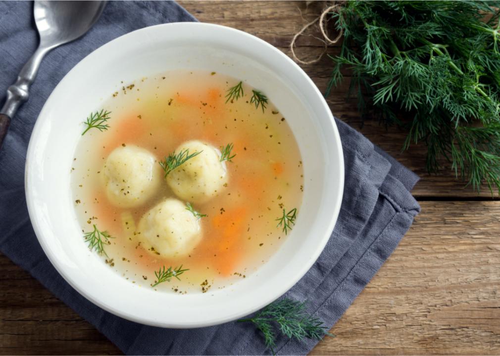 A bowl of matzo ball soup on a table. 