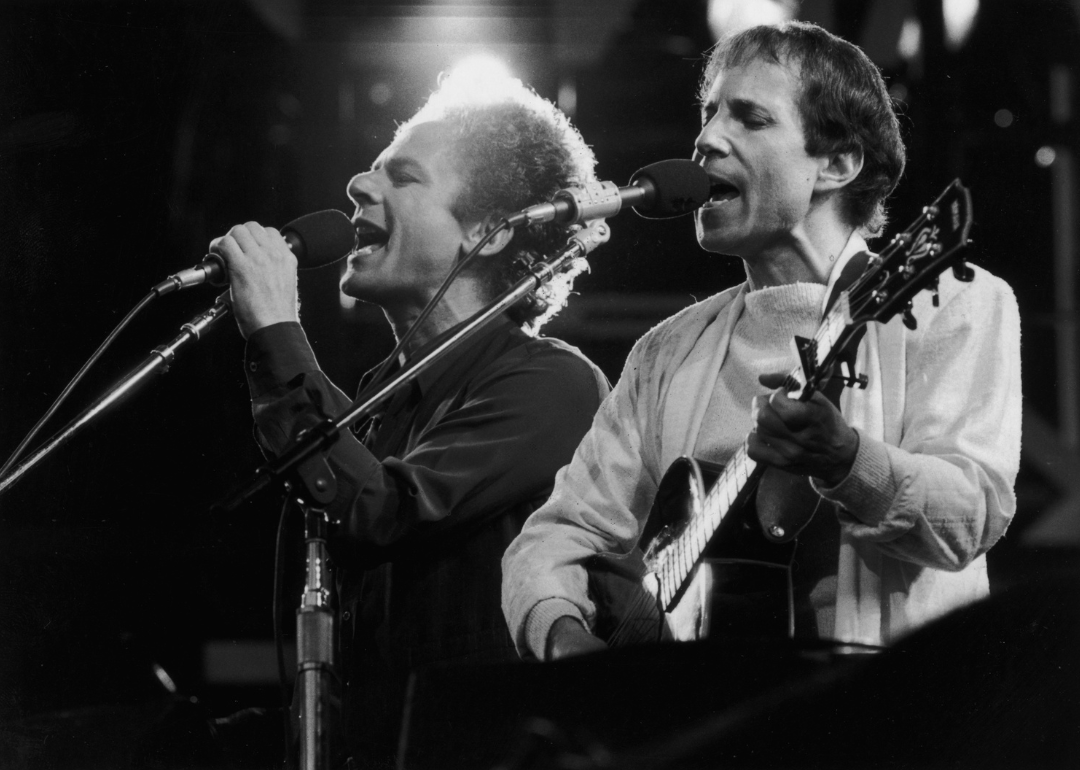 Art Garfunkel and Paul Simon perform on stage.
