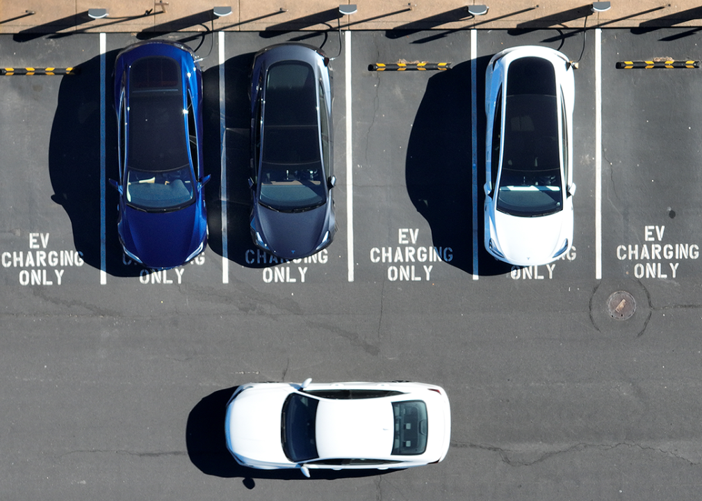 Aerial view of electric vehicles charging in parking lot.