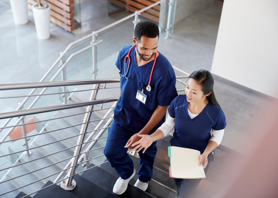 Two nurses talking in stairwell.