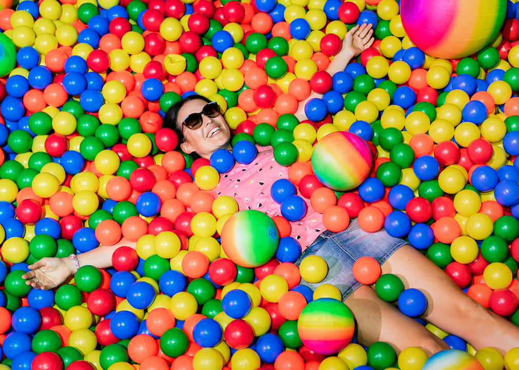 Woman smiling in colorful ball pool.