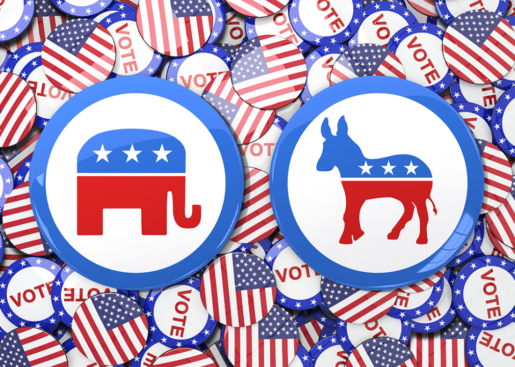 Republican elephant and Democratic donkey on top of American flag and vote stickers.