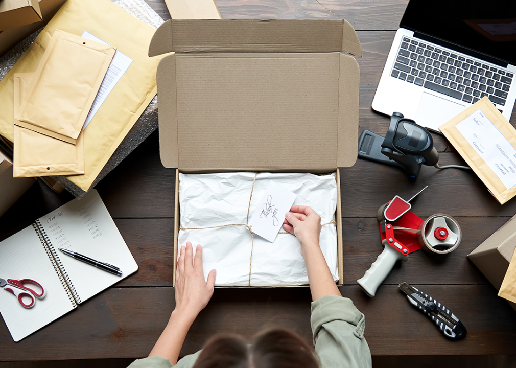 Person preparing box for shipping e-commerce order.