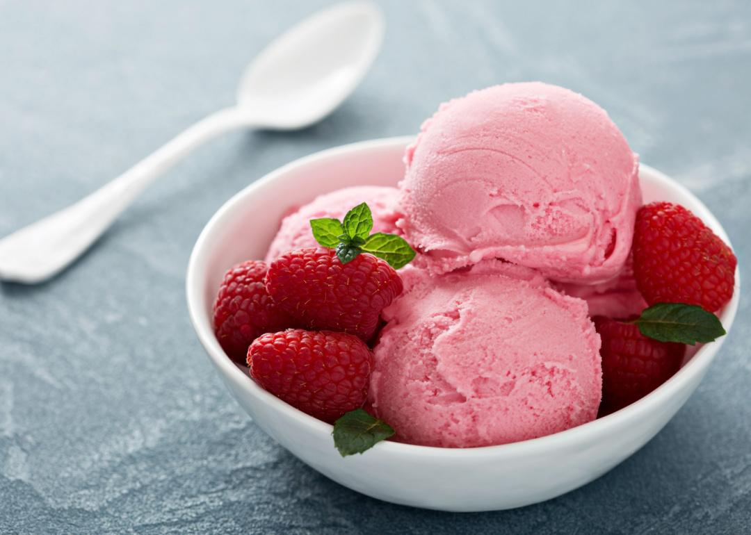 Close up of raspberry ice cream with fresh raspberries.