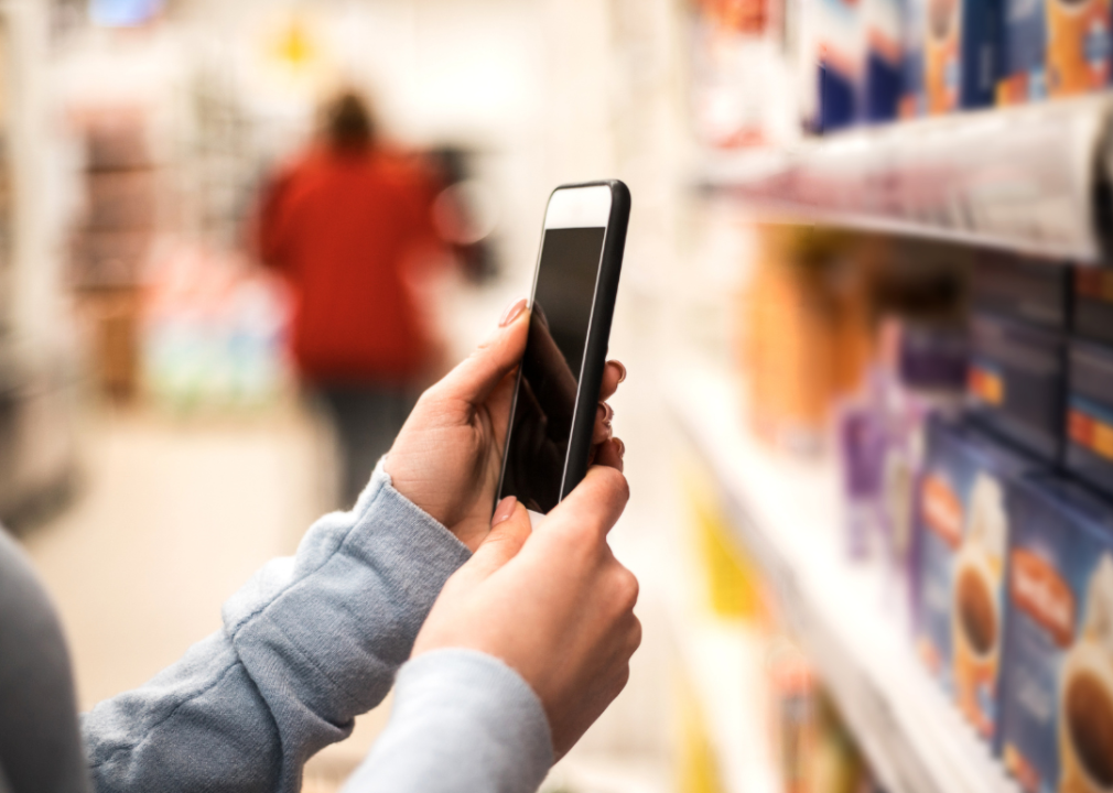 Woman using smartphone in grocery store