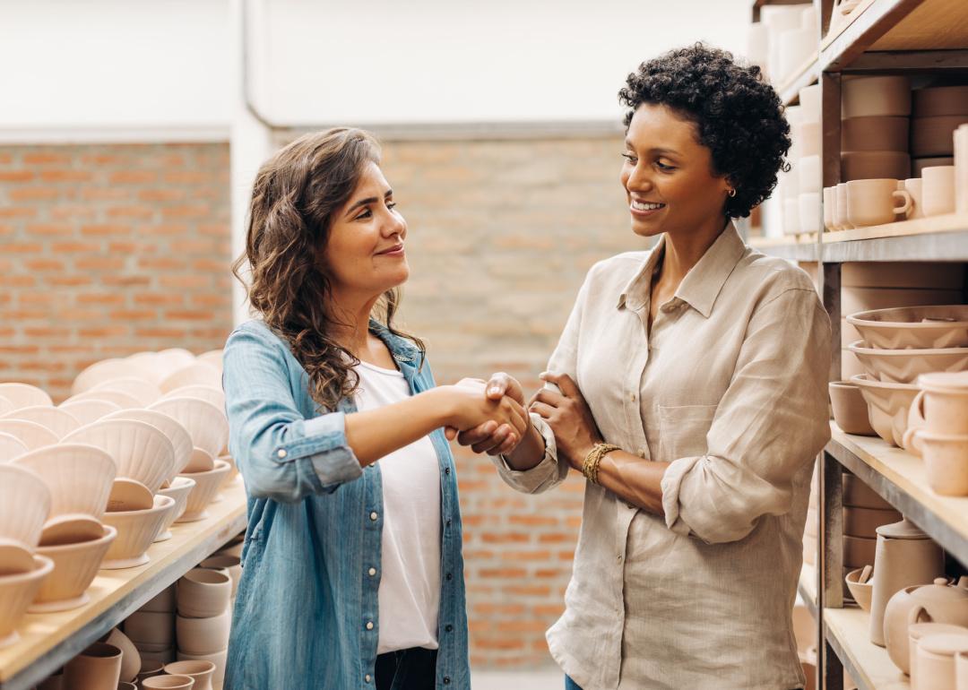 Two women business owners shaking hands.