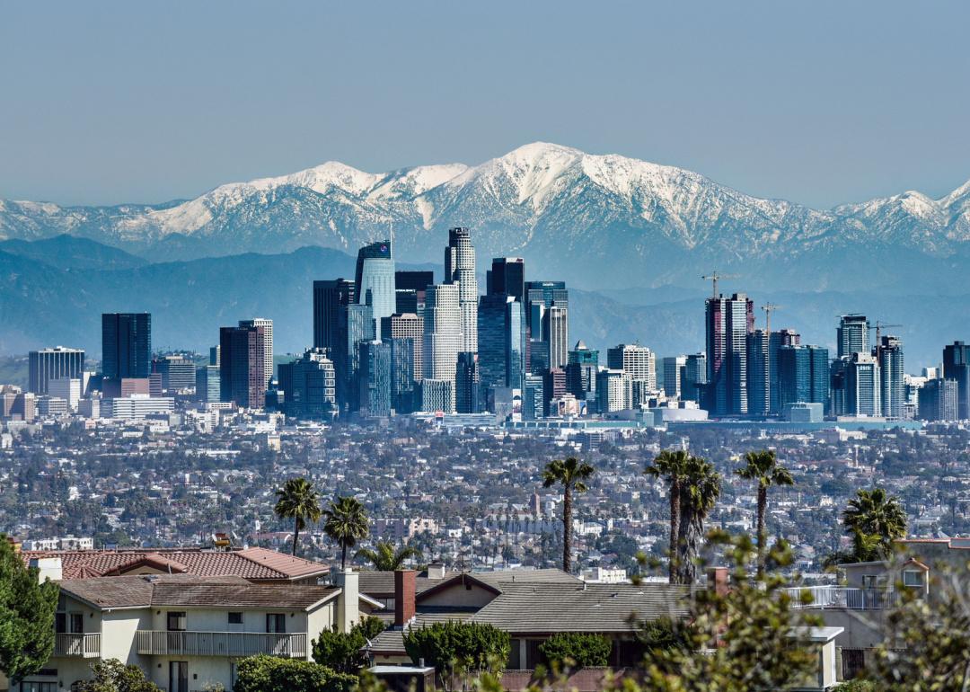 Downtown Los Angeles skyline with snow-capped San Gabriel Mountains in background.