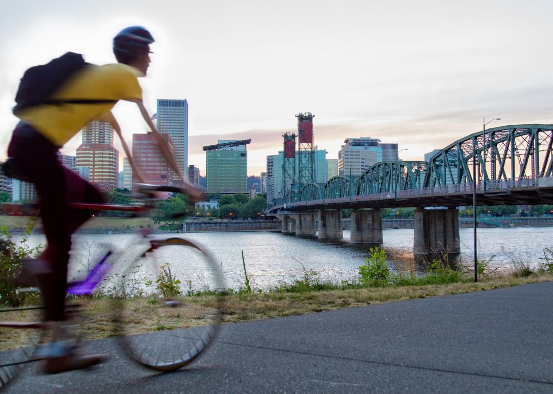 Person riding a bicycle along river in Portland