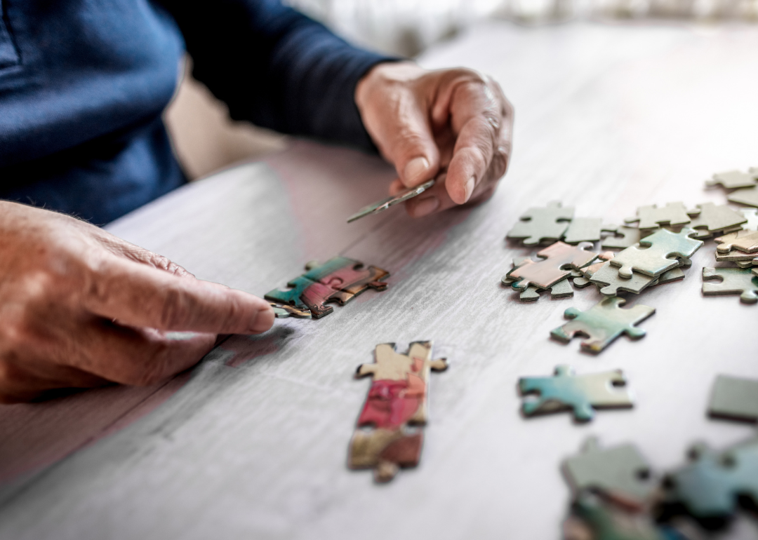 Senior hands holding puzzle pieces.