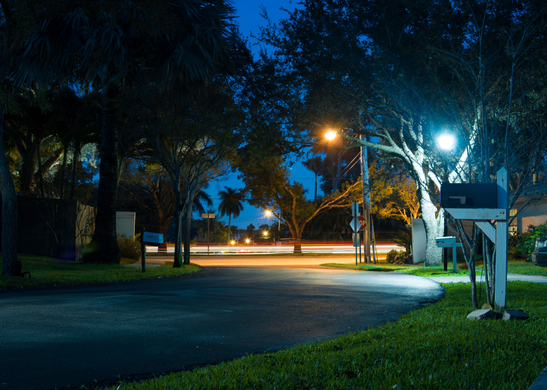 Neighborhood road with mailboxes and street lamps.