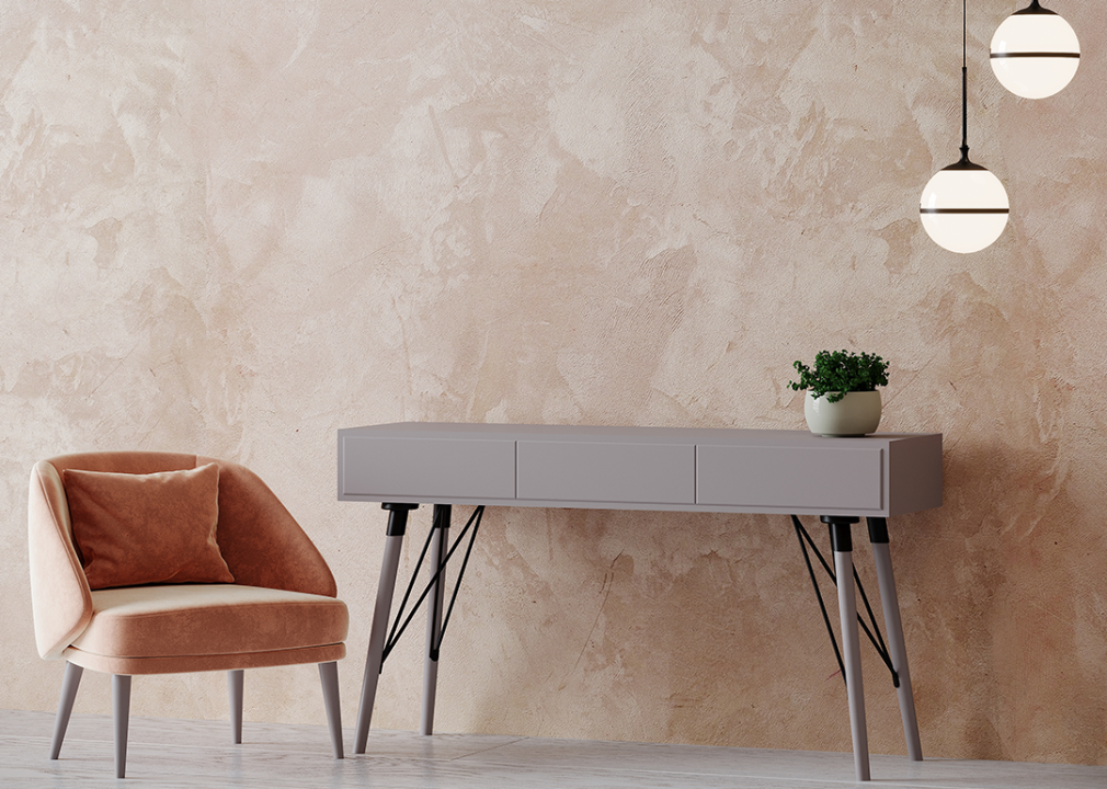 Wall detail made of Venetian plaster in warm tones with chair and side table.