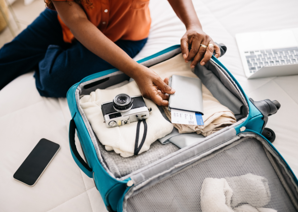 Woman packing carry on bag with essentials.