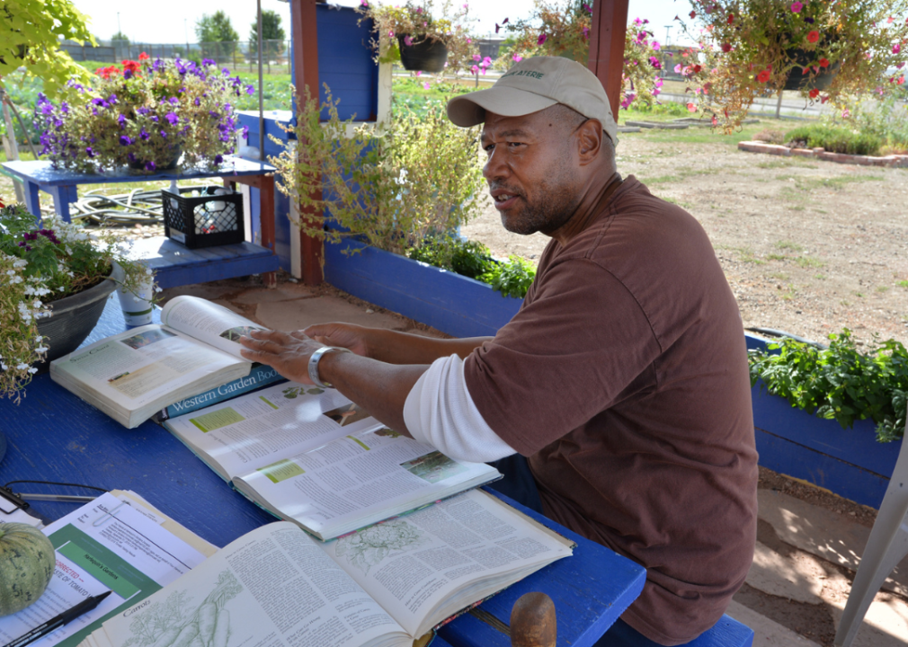 An inmate consults garden books at Boulder County Jail’s organic garden